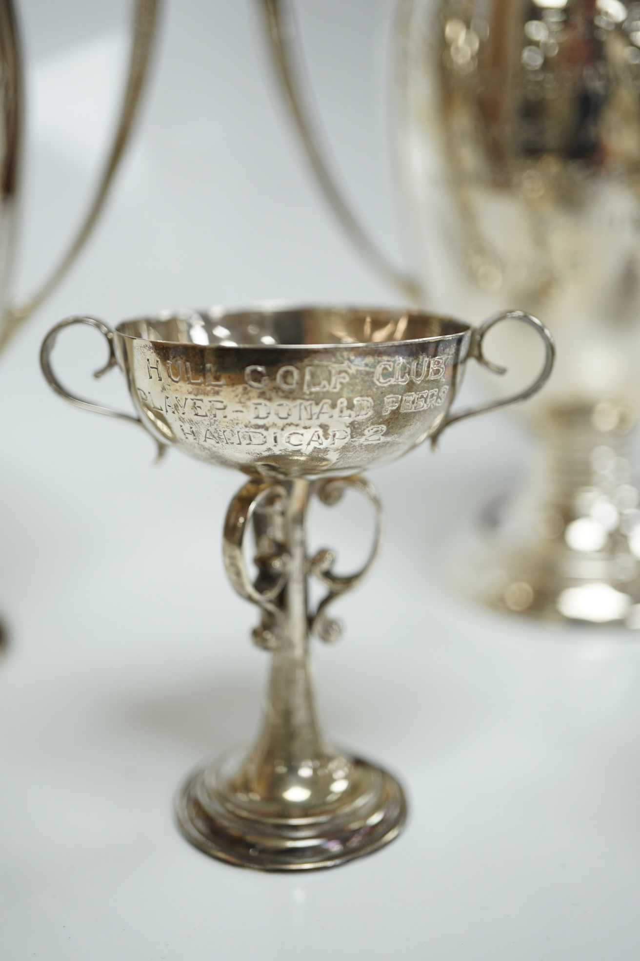 Five assorted small silver trophy cups including a pair by Edward Barnard & Sons, London, 1936, 12.7cm, 20.5cm. Condition poor to fair